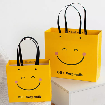 Sac de papier inférieur de sourire d'OIN de visage de Papier d'emballage de place jaune résistante aux chocs de sacs en papier